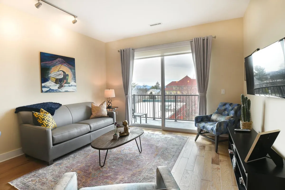 This interior image spotlights a contemporary lobby or shared lounge space, complete with a plush sofa, coffee table, and large window. The setting feels inviting and secure, ideal for welcoming guests as they transition from arrival to relaxation.